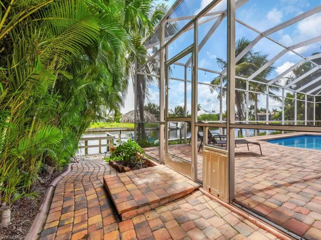 View of patio featuring a lanai and a water view