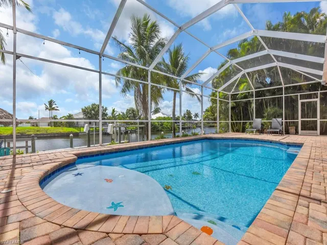 View of swimming pool featuring a lanai, a water view, and a patio area