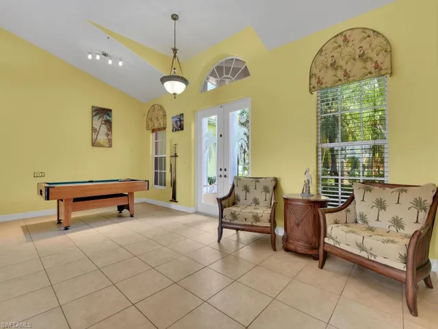 Recreation room with french doors, light tile patterned floors, billiards, and vaulted ceiling
