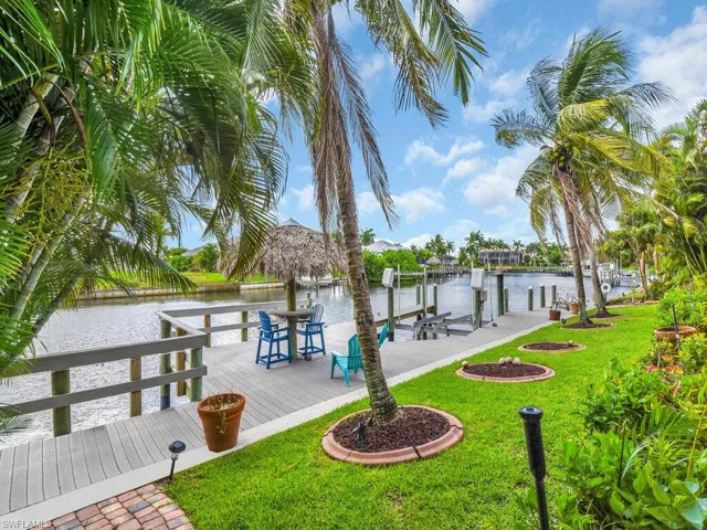 Dock area with a water view and a lawn