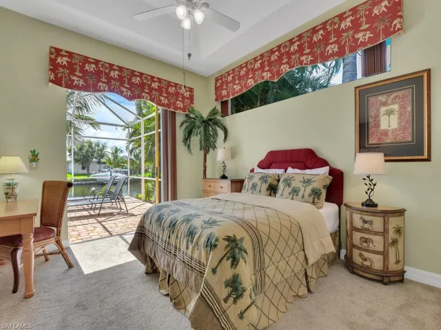 Bedroom with ceiling fan, a water view, access to exterior, and carpet