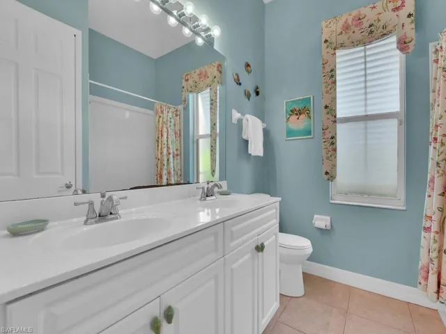 Bathroom featuring vanity, tile patterned flooring, toilet, and a shower with curtain