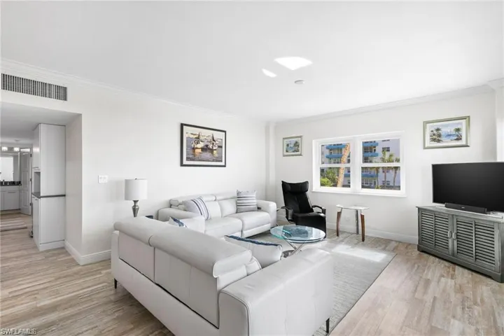 Living room featuring ornamental molding and light wood-type flooring