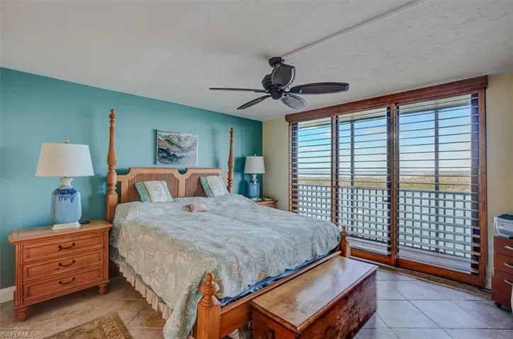 OWNER'S SUITE WITH IMPACT SLIDING DOORS WITH DIRECT ESTERO BAY VIEWS.  WOOD PLANTATION SHUTTERS.