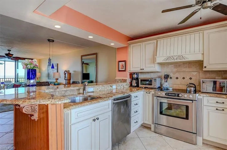 BEAUTIFUL GRANITE AND FULL-HEIGHT TILED BACKSPLASH.  LIGHTED TRAY CEILING.  RECESSED LIGHTING OVER BREAKFAST BAR.  UNDER-MOUNT STAINLESS STEEL SINK.