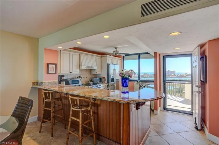 BREAKFAST BAR WITH BEAUTIFUL WOOD DETAILS AND GRANITE COUNTERTOP