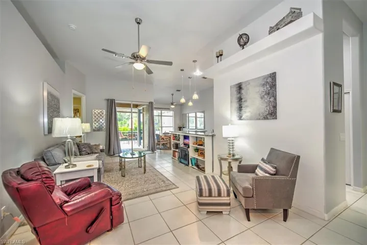 Living room with ceiling fan and light tile floors
