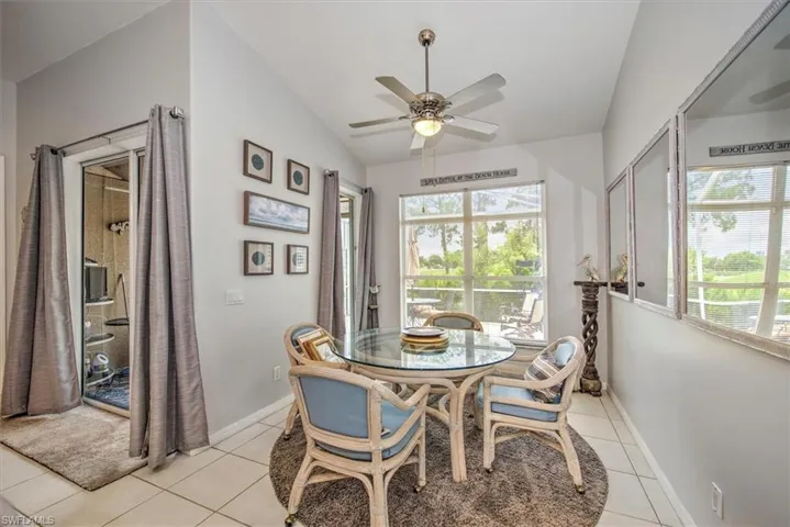 Dining area with a wealth of natural light, vaulted ceiling, and light tile floors