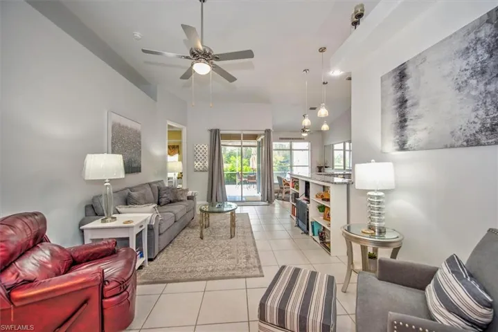 Living room with ceiling fan and light tile floors