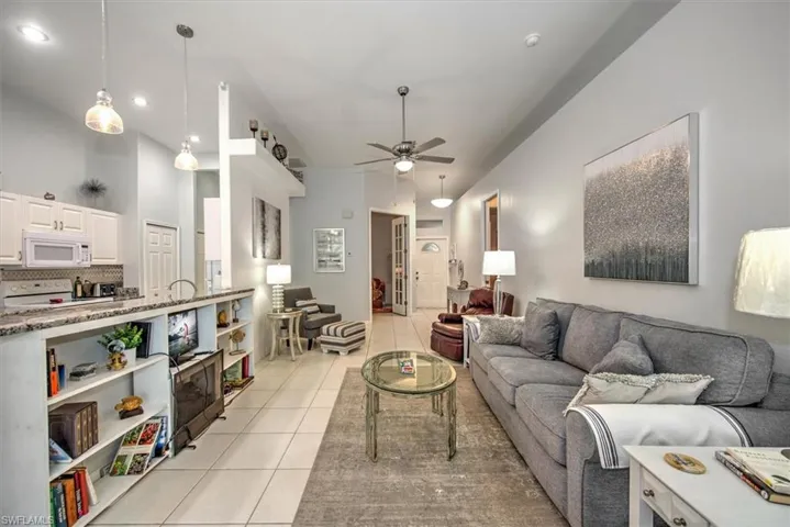 Tiled living room featuring a high ceiling and ceiling fan
