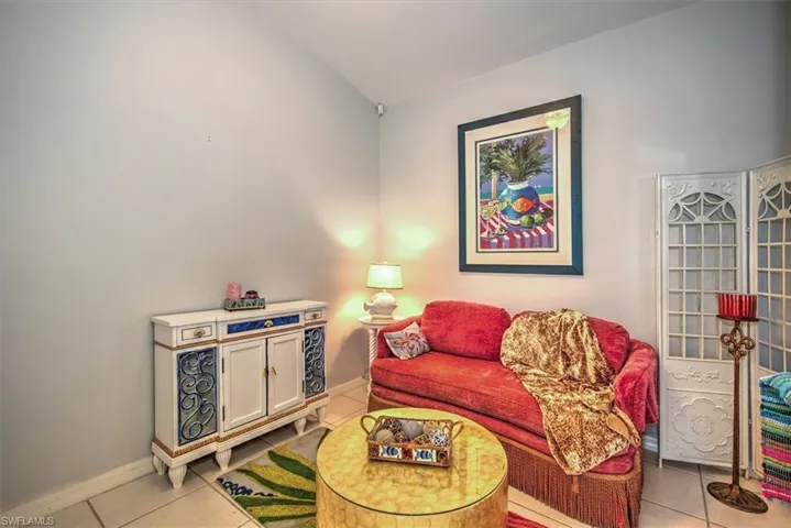 Tiled living room featuring lofted ceiling