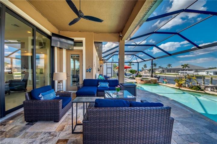 The 10 Ft sliding Glass Doors lead to your oversized custom Patio with Travertine Floors, the 3 TV's on Patio will stay with home.  This home was built with the outdoor enthusiast in mind.  This desired Northern exposure home was built with the pool built out away from the home to capture full sun on the pool all day and shade on the under truss porch.