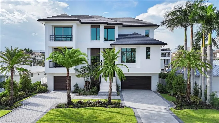 Modern home with stucco siding, a garage, and decorative driveway