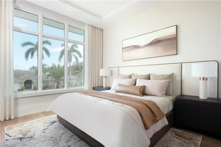 Bedroom with wood finished floors and multiple windows