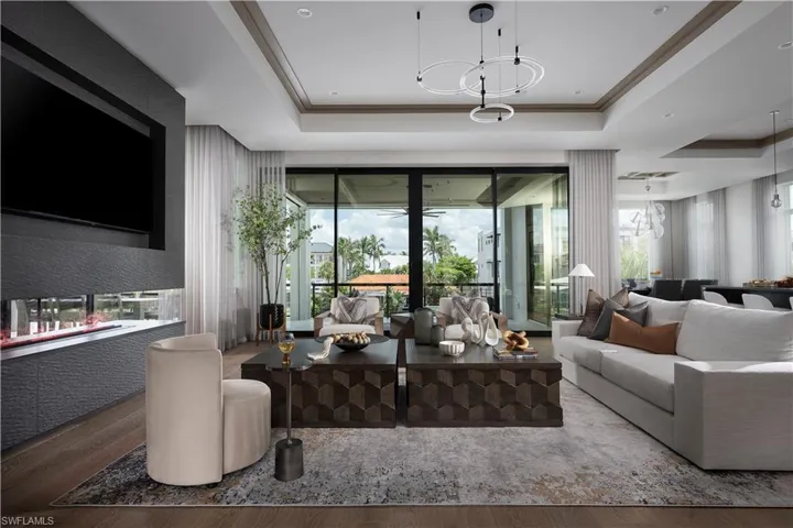 Living room with a tray ceiling and wood finished floors