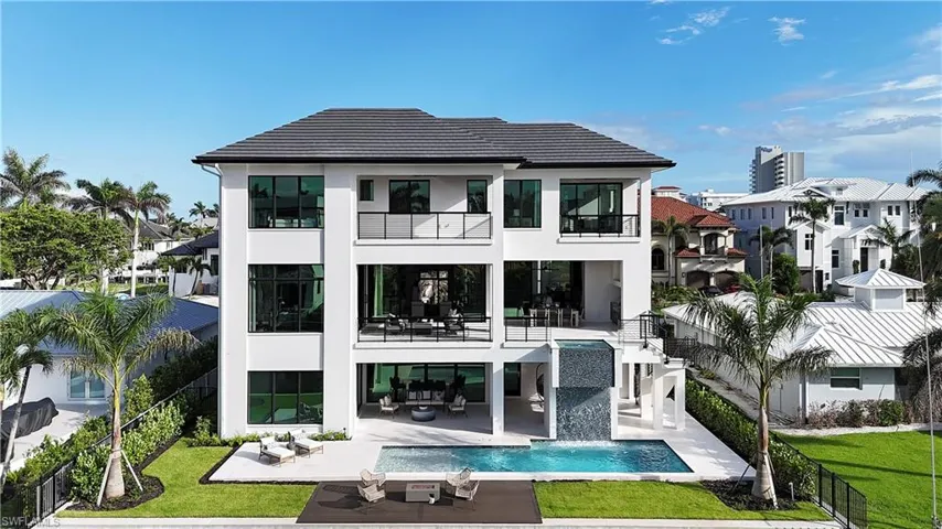 Back of property featuring a balcony, stucco siding, a fenced backyard, and a patio area