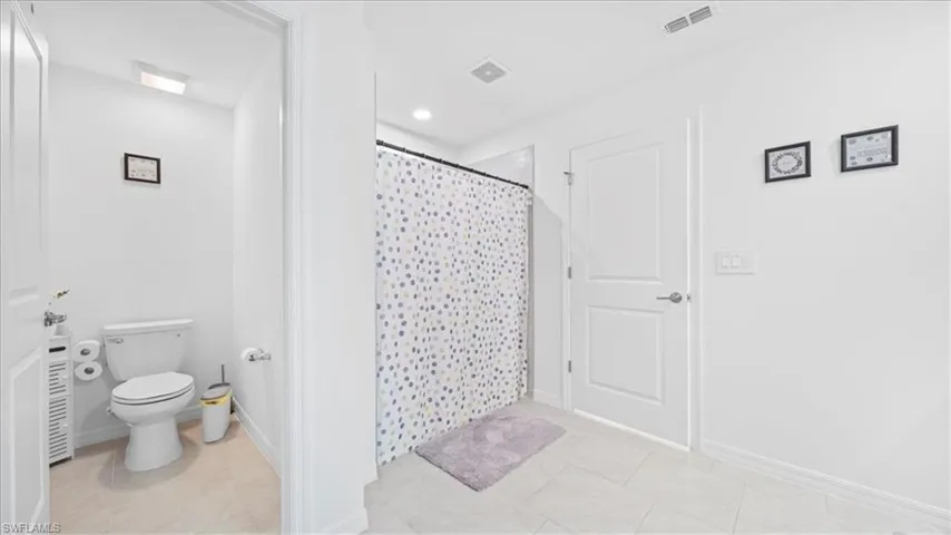 Bathroom featuring a shower with curtain, light tile patterned floors, and recessed lighting