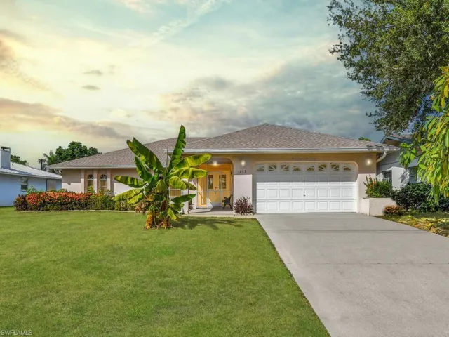 Single story home featuring stucco siding, a front lawn, concrete driveway, an attached garage, and roof with shingles