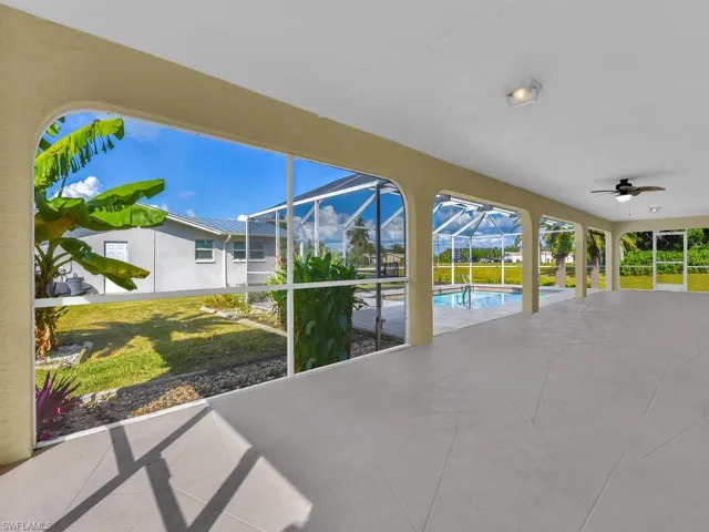 View of patio featuring a sunroom, a lanai, a ceiling fan, and an outdoor pool