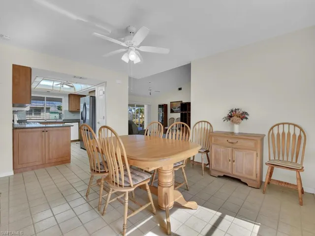 Dining space featuring vaulted ceiling, a ceiling fan, and light tile patterned floors