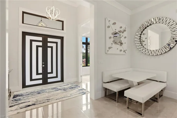 Entryway with ornamental molding and hanging lights