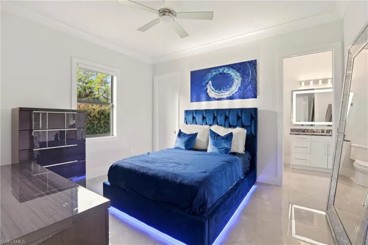 Bedroom featuring crown molding, ceiling fan, and ensuite bathroom