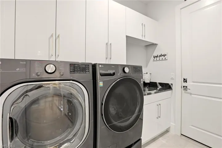 Laundry area with cabinet space and washing machine and clothes dryer