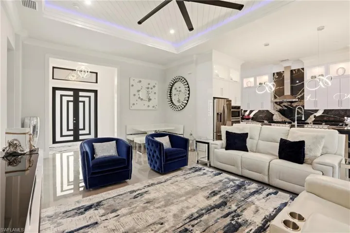 Living area featuring ceiling fan, crown molding, and a tray ceiling