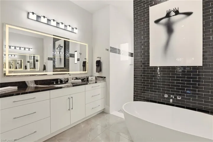 Full bath featuring walk in shower, a freestanding tub, and vanity