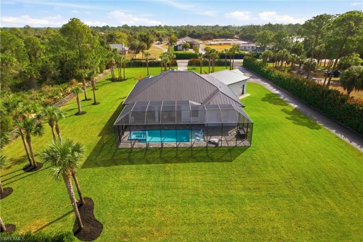 View from above of property featuring a pool area and a tree filled landscape