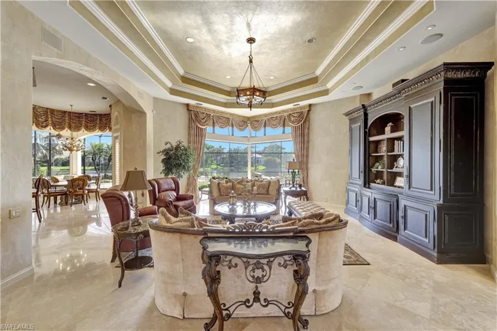 Sliding doors open to an expansive lanai and a beautiful pool area, seamlessly blending indoor and outdoor living.