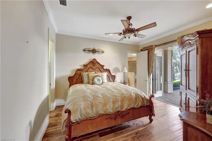 A second guest bedroom is located opposite the primary, featuring an ensuite full bath and pool access.