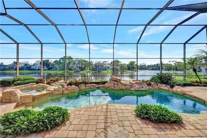 A sparkling pool and spa are enhanced by lush foliage creating a tropical retreat.