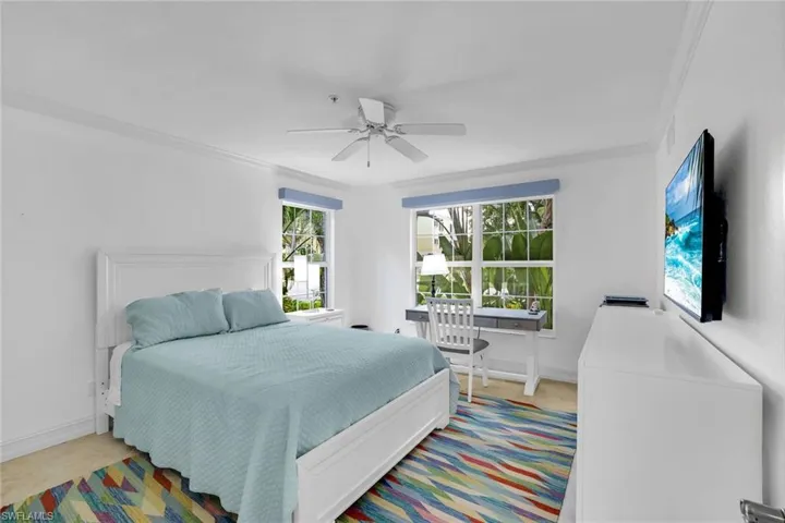Bedroom with ornamental molding and a ceiling fan