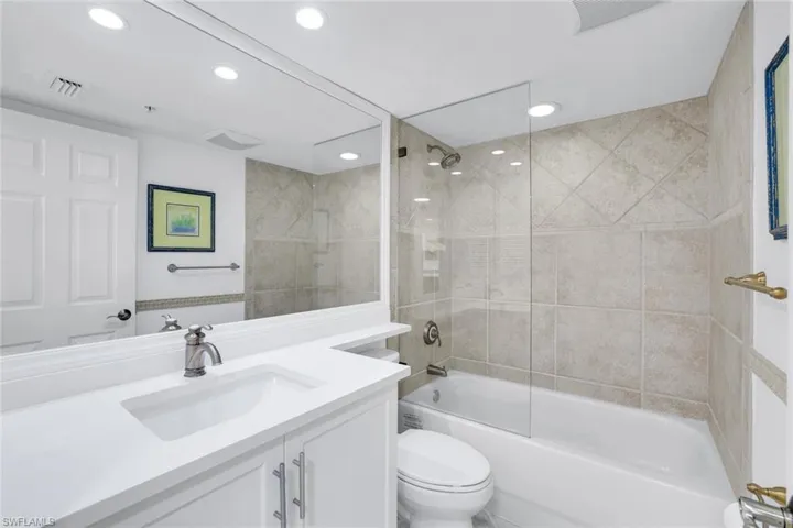 Bathroom featuring vanity, shower / tub combination, and recessed lighting