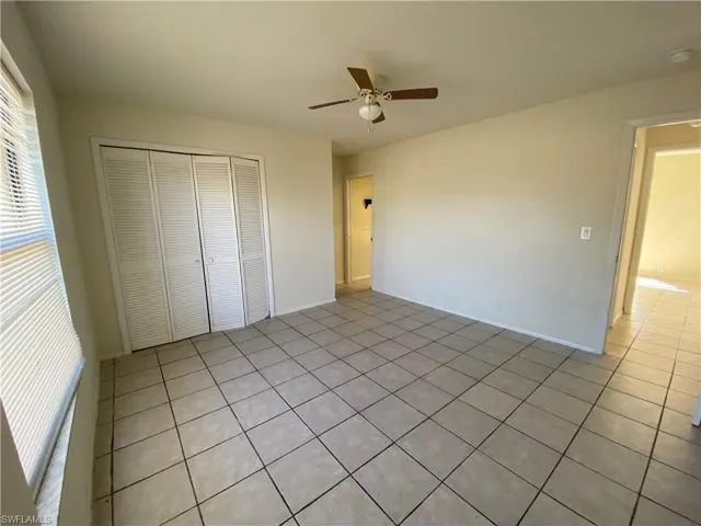 Unfurnished bedroom featuring light tile patterned flooring, a closet, and ceiling fan