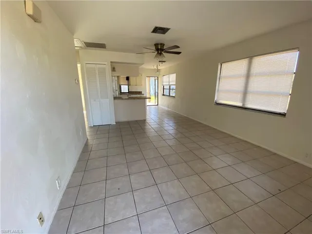Unfurnished living room with light tile patterned flooring and ceiling fan