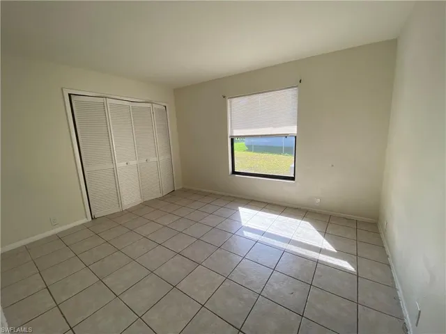 Unfurnished bedroom featuring light tile patterned flooring and a closet