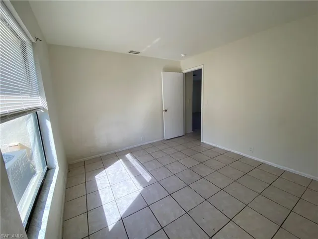 Unfurnished room featuring light tile patterned flooring and baseboards