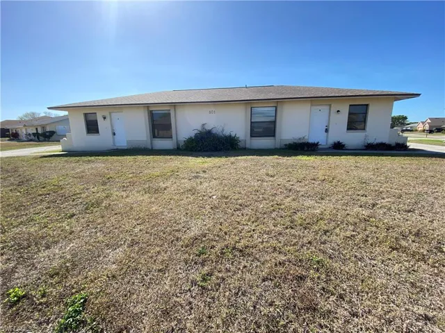 Ranch-style home with stucco siding and a front lawn