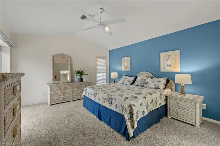 Bedroom featuring carpet, vaulted ceiling, and ceiling fan