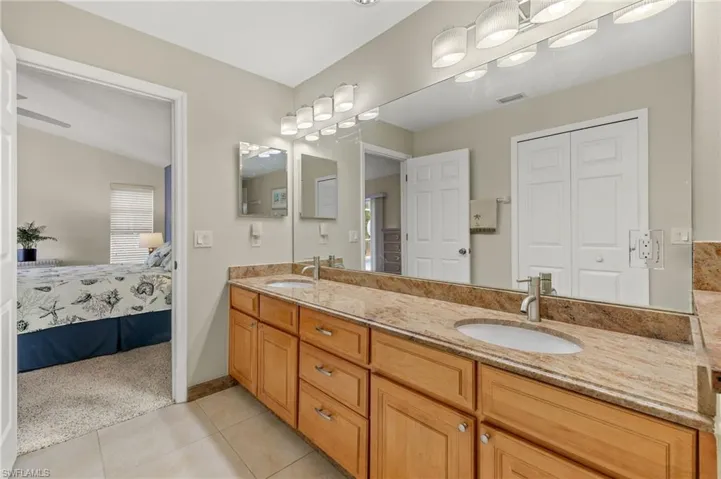 Bathroom with tile patterned floors, ceiling fan, vanity, and lofted ceiling