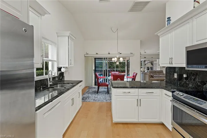 Kitchen featuring white cabinets, sink, light wood-type flooring, appliances with stainless steel finishes, and a healthy amount of sunlight