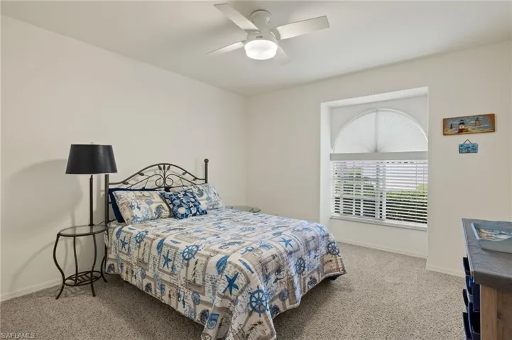 Carpeted bedroom featuring ceiling fan