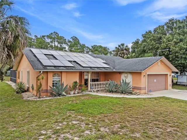 Front of home, featuring lion fountain solar panels, and an attached garage. Roof was replaced in 2014.  Home & pool are sitting on flood zone X  no mandatory flood insurance needed!