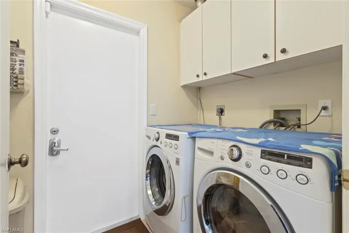 Dedicated laundry area featuring overhead cabinetry.