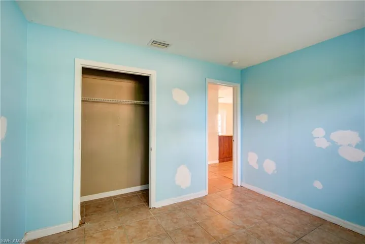 Unfurnished bedroom featuring tile patterned flooring and a closet