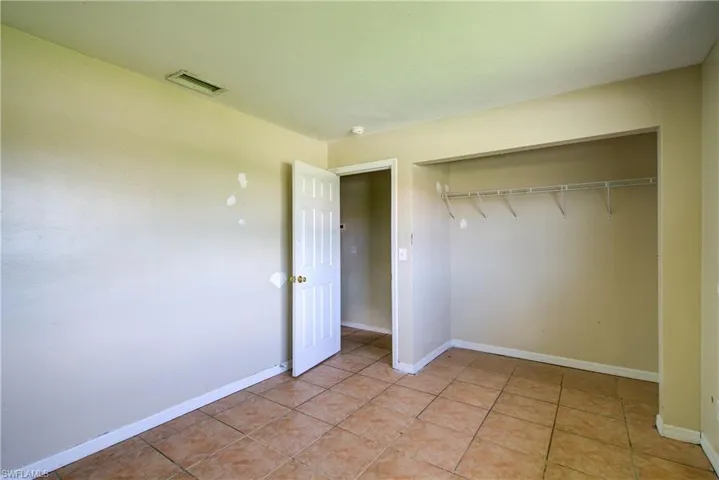 Unfurnished bedroom with a closet and light tile patterned flooring