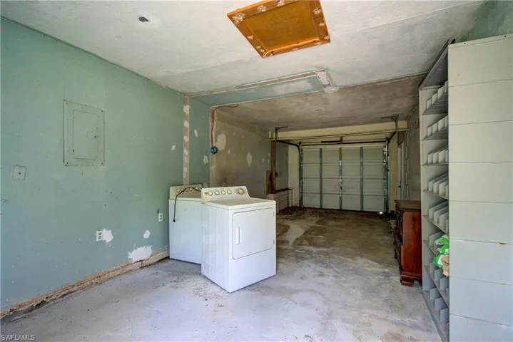 Garage with electric panel and separate washer and dryer