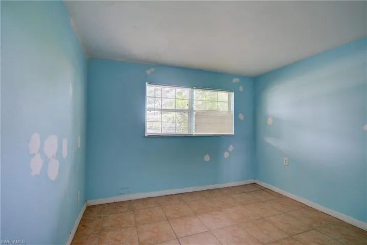 Unfurnished room featuring baseboards and light tile patterned floors